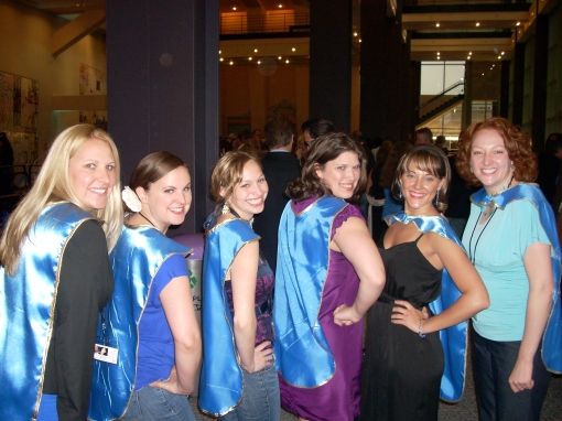 Kempe Champions in superhero capes: Kelley McHale, Beth Stefl, Leigh Clasby, Pam Wharton, Ashleigh Sedbrook, and Mae Desaire.